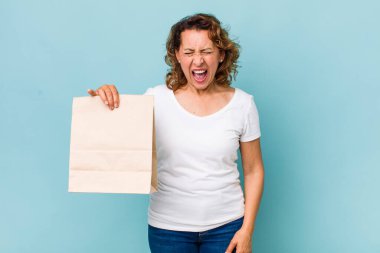 Orta yaşlı bir kadın agresif bir şekilde bağırıyor, çok kızgın görünüyor. konsepti kaldır