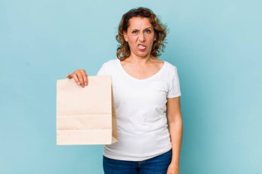 Orta yaşlı bir kadın iğreniyor, sinirleniyor ve dili dışarı çıkıyor. konsepti kaldır