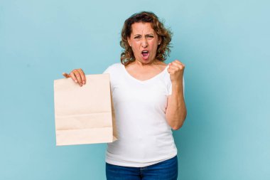 Orta yaşlı bir kadın sinirli bir ifadeyle agresif bir şekilde bağırıyor. konsepti kaldır