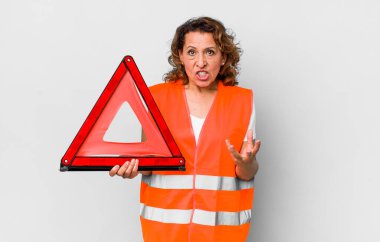 Orta yaşlı bir kadın sinirli, sinirli ve sinirli görünüyor. araba acil konsepti