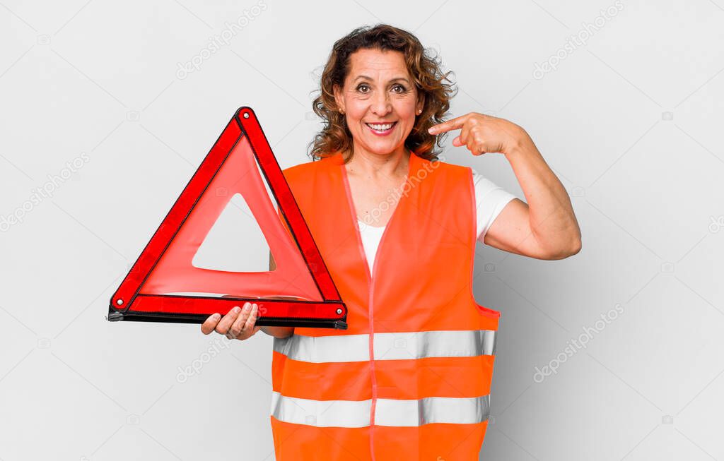 middle age woman smiling confidently pointing to own broad smile. car emergency concept