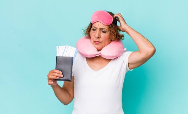 Orta yaşlı kadın şaşkın ve kafası karışık, kaşınan bir kafa hissediyor. uçuş yolcusu