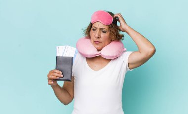 Orta yaşlı kadın mutlu bir şekilde gülümsüyor ve hayal kuruyor ya da şüphe ediyor. uçuş yolcusu