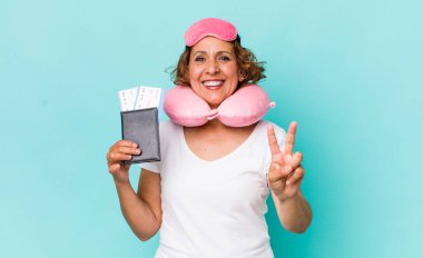 Orta yaşlı kadın gülümsüyor ve arkadaş canlısı görünüyor, iki numarayı gösteriyor. uçuş yolcusu