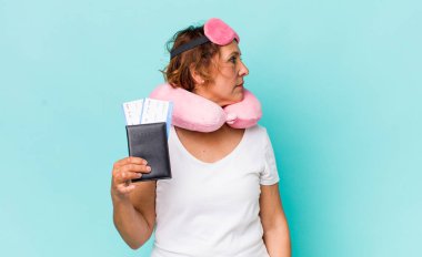 Profil görüşü olan orta yaşlı bir kadın hayal kuruyor ya da hayal kuruyor. uçuş yolcusu