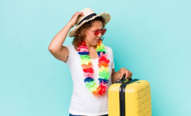 Orta yaşlı kadın mutlu bir şekilde gülümsüyor ve hayal kuruyor ya da şüphe ediyor. Yaz tatili konsepti