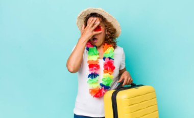 Orta yaşlı bir kadın şok olmuş, korkmuş ya da korkmuş görünüyor, yüzünü elleriyle kapatıyor. Yaz tatili konsepti