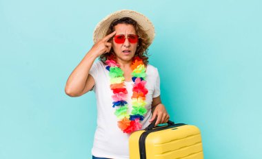 Orta yaşlı kadın kafası karışık ve şaşkın hissediyor, deli olduğunu gösteriyor. Yaz tatili konsepti