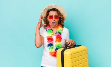 Orta yaşlı bir kadın ellerini havaya kaldırarak çığlık atıyor. Yaz tatili konsepti