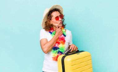 Orta yaşlı kadın düşünüyor, kuşkulu ve şaşkın hissediyor. Yaz tatili konsepti