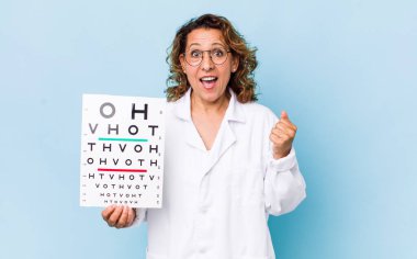 Orta yaşlı kadın şokta, gülüyor ve başarıyı kutluyor. vizyon testi kavramı