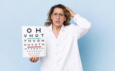 Orta yaşlı kadın kendini stresli, endişeli ya da korkmuş hissediyor. Elleri başının üstünde. vizyon testi kavramı