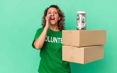 Orta yaşlı bir kadın kendini mutlu hissediyordu. Elleri ağzının kenarında bağırıyordu. gönüllü ve bağış konsepti