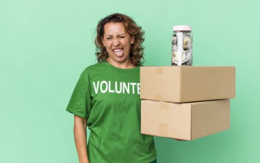 Neşeli ve asi tavırları olan orta yaşlı bir kadın şaka yapıyor ve dilini dışarı çıkarıyor. gönüllü ve bağış konsepti