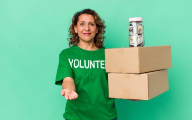 Orta yaşlı bir kadın arkadaşça gülümsüyor ve bir konsept sunuyor. gönüllü ve bağış konsepti