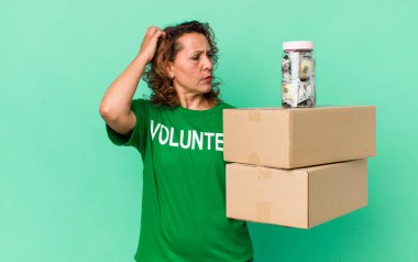 Orta yaşlı kadın mutlu bir şekilde gülümsüyor ve hayal kuruyor ya da şüphe ediyor. gönüllü ve bağış konsepti