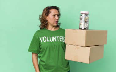 Orta yaşlı bir kadın üzgün, üzgün ya da kızgın hisseder ve bir tarafa bakar. gönüllü ve bağış konsepti