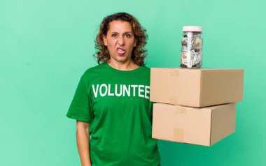 Orta yaşlı bir kadın iğreniyor, sinirleniyor ve dili dışarı çıkıyor. gönüllü ve bağış konsepti