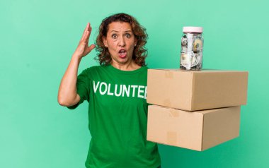 Orta yaşlı bir kadın ellerini havaya kaldırarak çığlık atıyor. gönüllü ve bağış konsepti