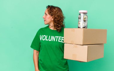 Profil görüşü olan orta yaşlı bir kadın hayal kuruyor ya da hayal kuruyor. gönüllü ve bağış konsepti