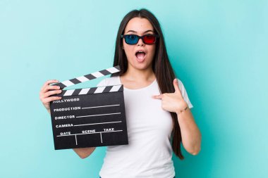 Şok olmuş ve ağzı açık, kendini işaret eden genç bir kadın. film konsepti