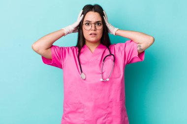 Genç bir kadın stresli, endişeli ya da korkmuş hissediyor. Elleri başının üstünde. Veterinerlik kavramı