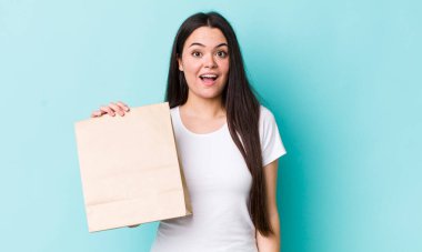 Genç yetişkin bir kadın mutlu ve hoş bir şekilde şaşırmış görünüyor. konsepti kaldır