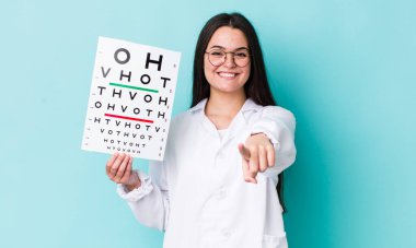 Genç yetişkin bir kadın kamerayı işaret ederek seni seçiyor. optik görüş testi konsepti