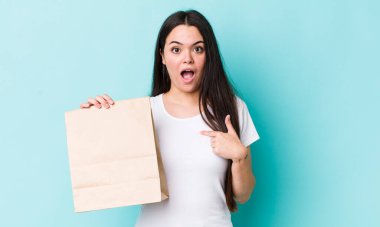 Şok olmuş ve ağzı açık, kendini işaret eden genç bir kadın. konsepti kaldır