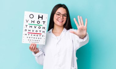 Genç yetişkin kadın gülümsüyor ve arkadaş canlısı görünüyor, beş numarayı gösteriyor. optik görüş testi konsepti