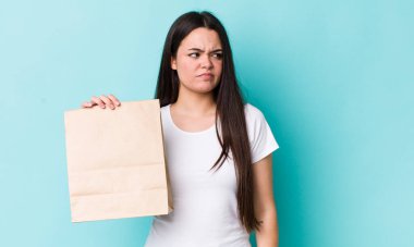 Genç yetişkin bir kadın üzgün, üzgün ya da kızgın hissediyor ve yan tarafa bakıyor. konsepti kaldır