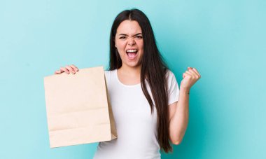 Genç bir kadın öfkeli bir ifadeyle agresif bir şekilde bağırıyor. konsepti kaldır