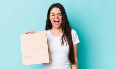 Genç yetişkin bir kadın agresif bir şekilde bağırıyor, çok kızgın görünüyor. konsepti kaldır