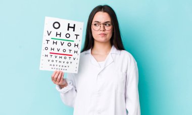 Genç yetişkin bir kadın üzgün, üzgün ya da kızgın hissediyor ve yan tarafa bakıyor. optik görüş testi konsepti