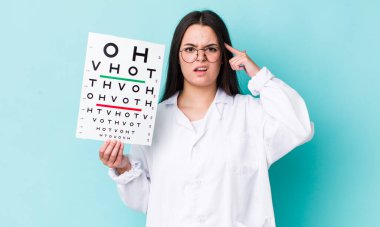Genç yetişkin bir kadın kafası karışık ve şaşkın hissediyor, senin deli olduğunu gösteriyor. optik görüş testi konsepti