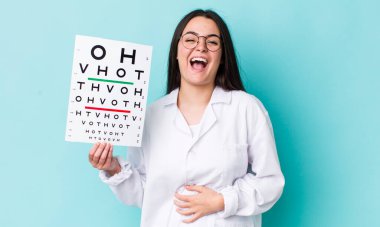 Genç yetişkin bir kadın komik bir şakaya yüksek sesle gülüyor. optik görüş testi konsepti
