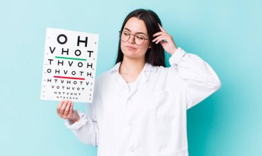 Genç yetişkin kadın mutlu bir şekilde gülümsüyor ve hayal kuruyor ya da şüphe ediyor. optik görüş testi konsepti