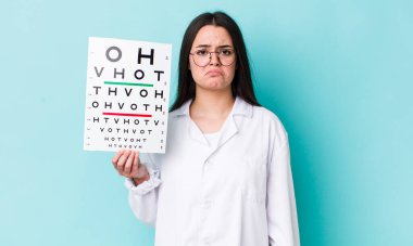 Genç bir kadın üzgün ve mızmızlanıyor. Mutsuz bir bakışı var ve ağlıyor. optik görüş testi konsepti