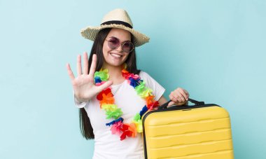 Genç yetişkin kadın gülümsüyor ve arkadaş canlısı görünüyor, beş numarayı gösteriyor. Yaz tatili konsepti