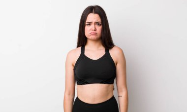 Genç bir kadın üzgün ve mızmızlanıyor. Mutsuz bir bakışı var ve ağlıyor. fitness konsepti