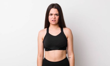 Genç bir kadın şaşkın ve şaşkın hissediyor. fitness konsepti