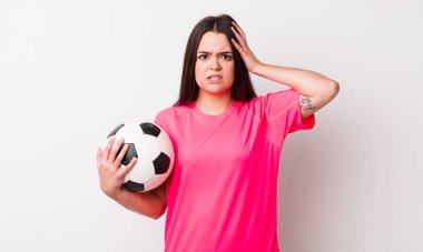 Genç bir kadın stresli, endişeli ya da korkmuş hissediyor. Elleri başının üstünde. futbol kavramı