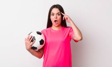 Genç yetişkin kadın şaşırmış görünüyor, yeni bir düşünce, fikir ya da konsept fark ediyor. futbol kavramı