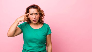 Orta yaşlı İspanyol kadın şaşkın ve şaşkın hissediyor. Deli, deli ya da aklını kaçırmış olduğunu gösteriyor.