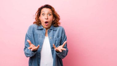 Orta yaşlı İspanyol bir kadın aşırı derecede şaşırmış, şaşırmış, endişeli ve paniklemiş, stresli ve dehşete kapılmış görünüyor.