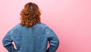 Orta yaşlı İspanyol kadın kafası karışık ya da dolgun ya da şüphe ve soru dolu, merak ediyor, elleri kalçasında, dikiz aynasından.