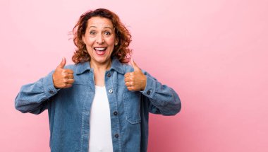 Orta yaşlı İspanyol kadın gülümsüyor. Mutlu, pozitif, kendinden emin ve başarılı görünüyor.