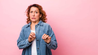 Orta yaşlı İspanyol kadın iğreniyor ve midesi bulanıyor. Pis kokan ya da kötü kokan bir şeyden kaçıyor.