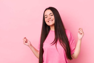 Genç bir kadın gülümsüyor, tasasız hissediyor, rahat ve mutlu, dans ediyor ve müzik dinliyor, bir partide eğleniyor.