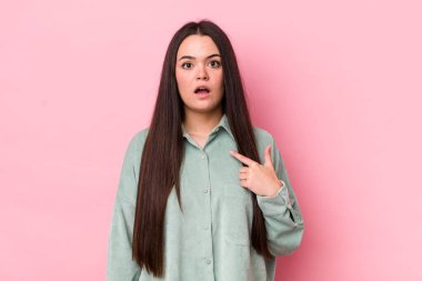 Şok olmuş ve şaşırmış genç bir kadın ağzı açık, kendini işaret ediyor.